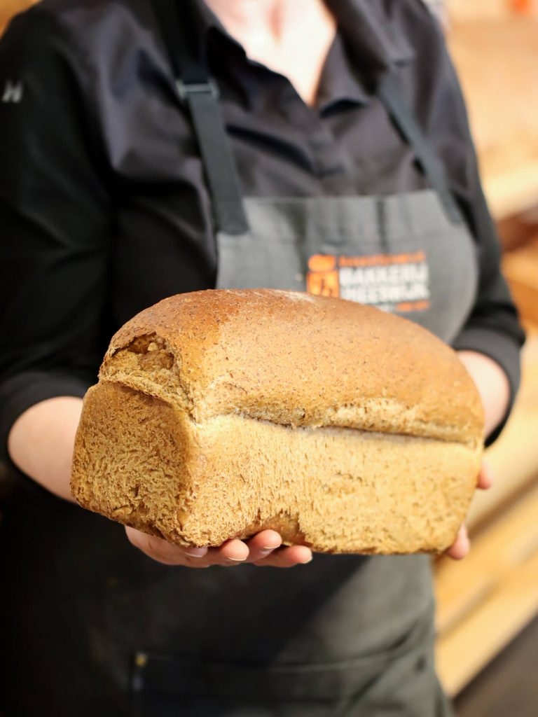 Bakker met vers gebakken brood in handen.