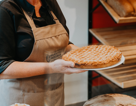 Bakker toont versgebakken taart in winkel